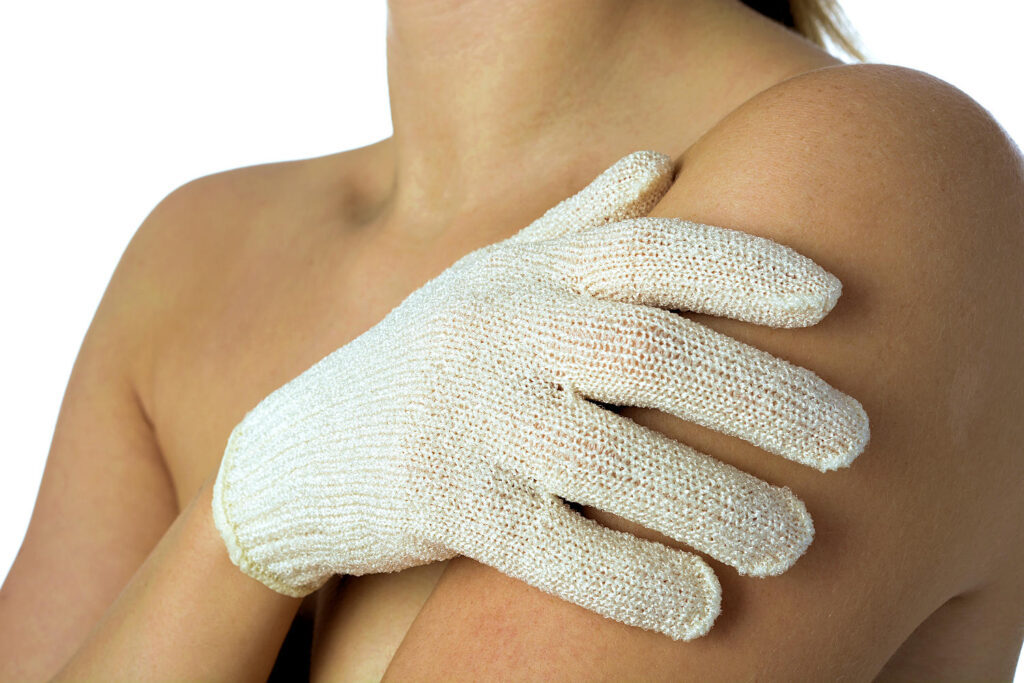 Woman applying self tannin lotion with glove