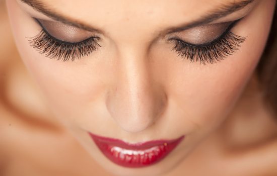 Girls face from above in full makeup with very good mascara applied